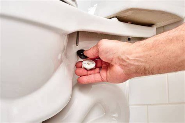 How do you tighten a Glacier Bay toilet seat?
