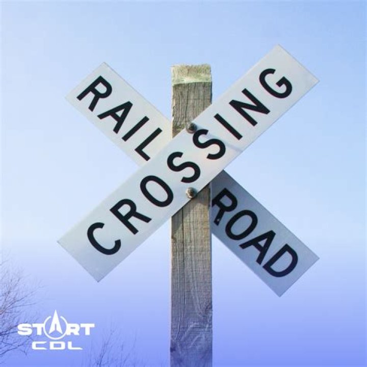 What must you do when you approach a Crossbuck sign?
