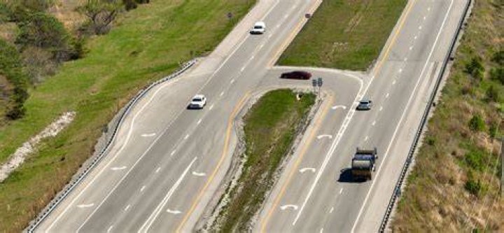 When driving on a two lane highway if an aggressive driver behind you rapidly flashes their headlights and then pulls out to pass you you should?